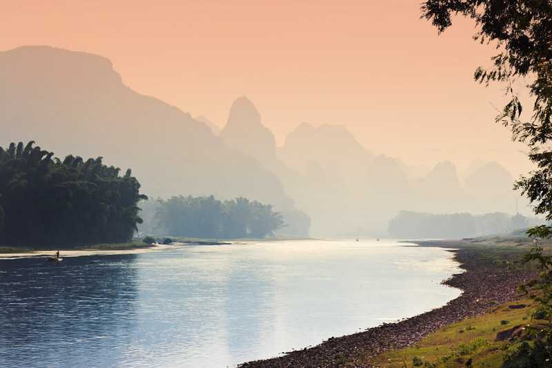 li-river-in-guilin-orange-colours-cast-over-the-sky-at-sunset-along-the-river